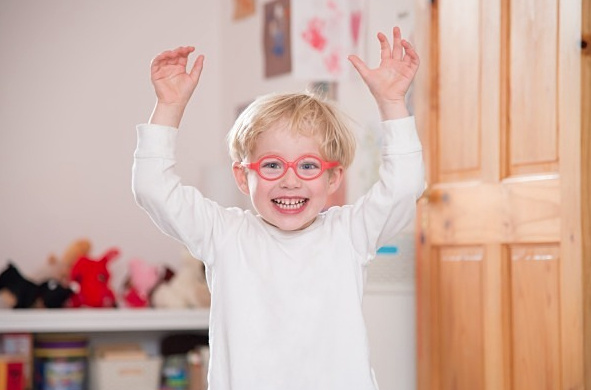 Boy throws hands in air excited about online resources for children in London during Covid