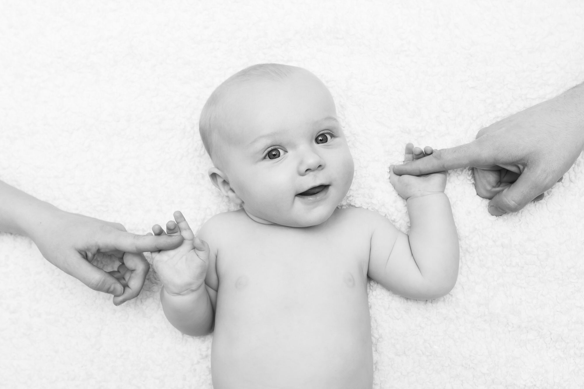 Baby holds mum's fingers in black and white photo in Notting Hill, London