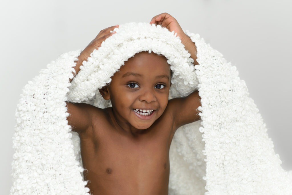 Child photohoot in Bromley, SE London - smiling boy under blanket