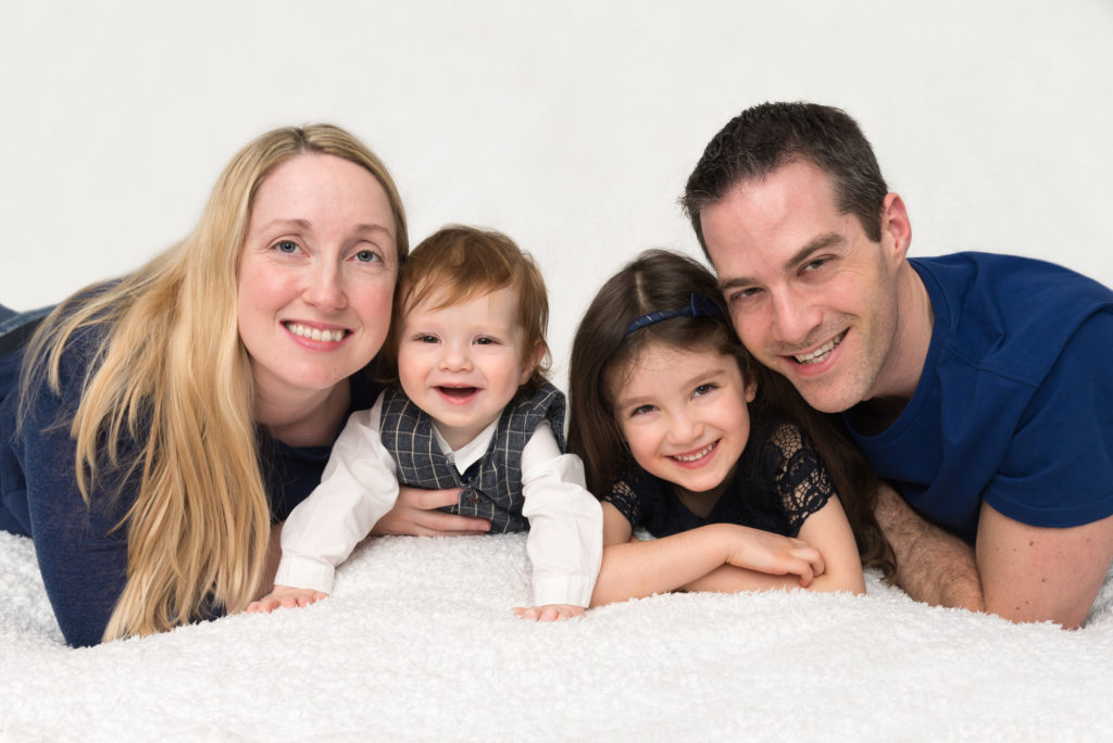 Family of four on a bed at a family photography session in Balham, South London