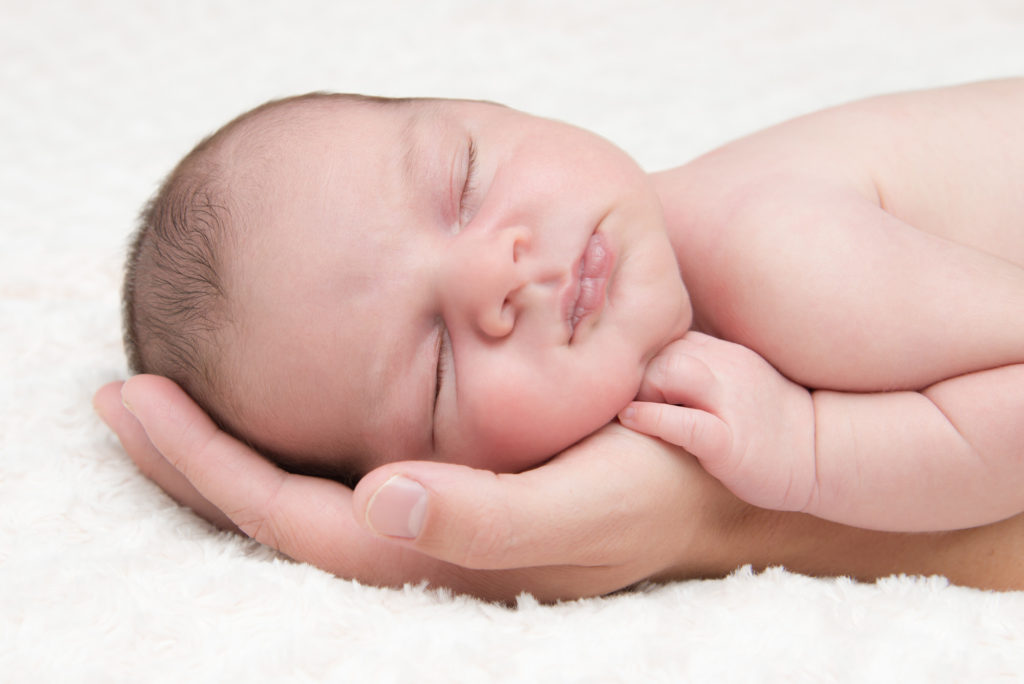Baby asleep in dad's hand at professional newborn photography session in Blackheath, London
