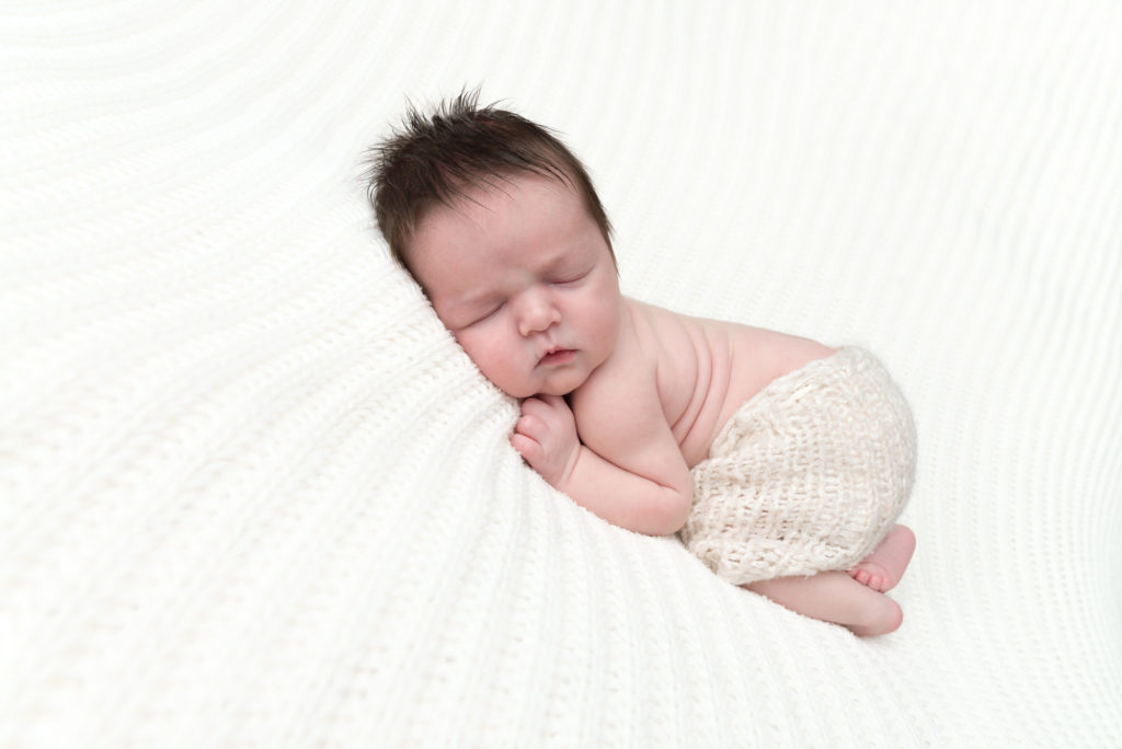 Tiny baby on tummy at newborn photography session in Knightsbridge, London