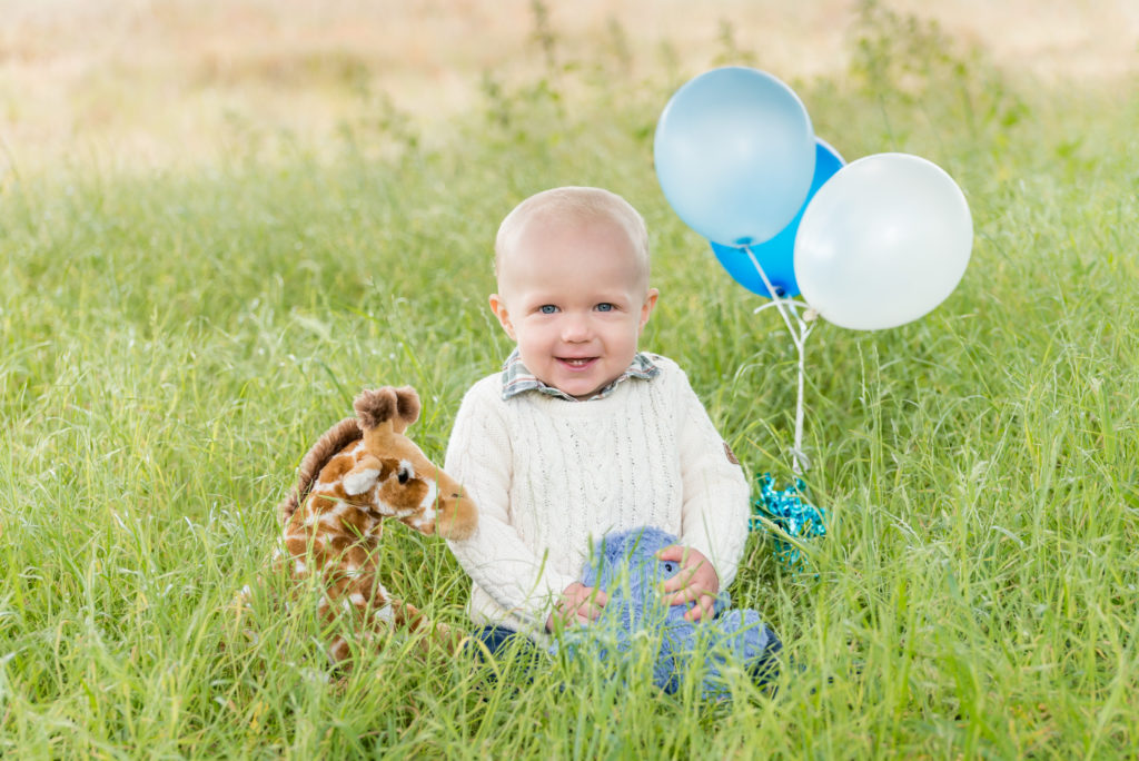 London baby photos - boy with balloons at first birthday in Clapham park